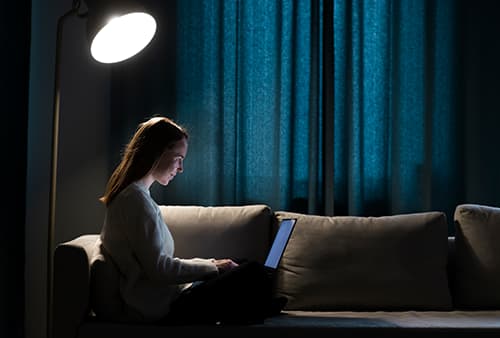 A woman studying at night on her laptop